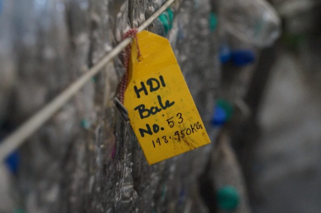 Close-up of a labeled HDPE plastic bale in a recycling facility for plastic waste management and recycling.