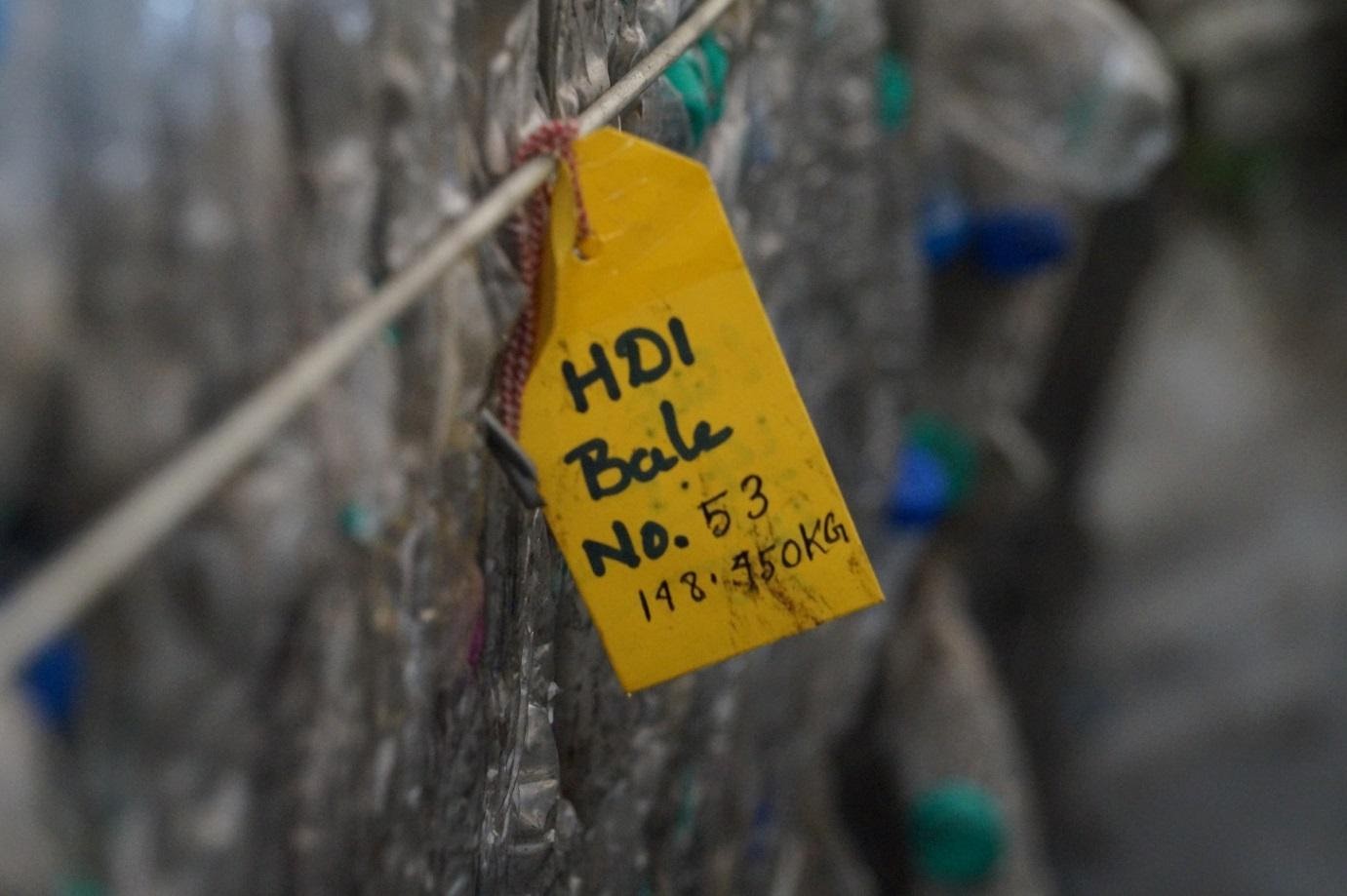 Close-up of a labeled HDPE plastic bale in a recycling facility for plastic waste management and recycling.