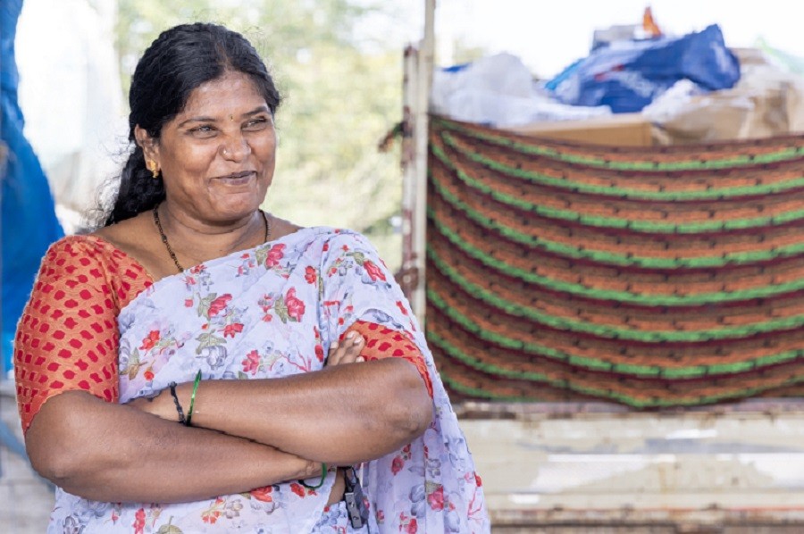 Smiling woman waste management worker at a recycling center promoting sustainable waste collection and environmental care.